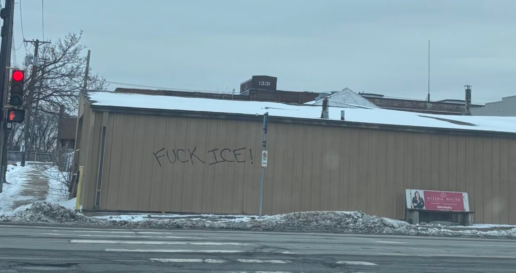 A photo of a building with grafitti stating "FUCK ICE!" spray-painted in its wall